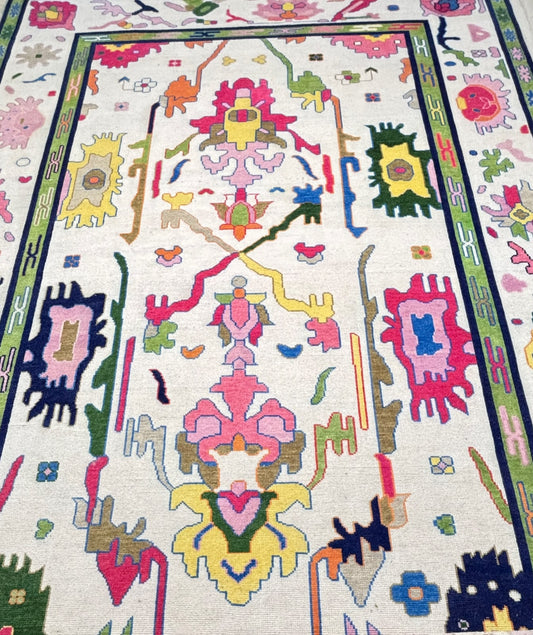 Handmade Scandinavian folk art wool rug featuring colorful geometric motifs on an ivory background with a green decorative border.