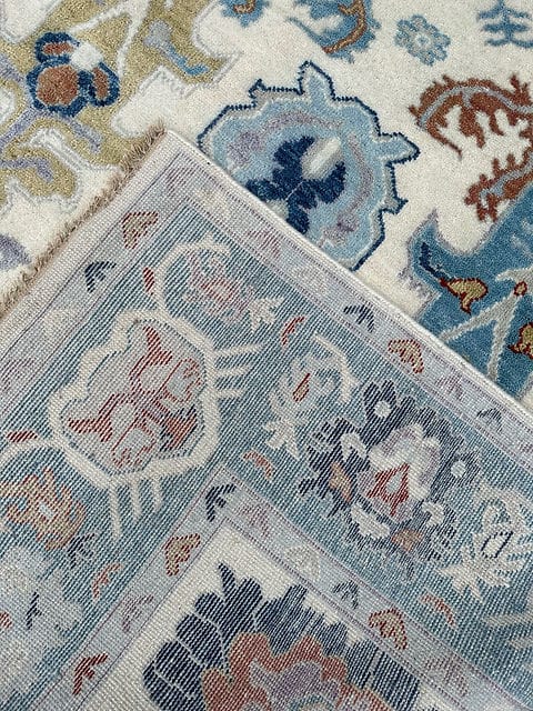 Handmade Oushak rug back side showing traditional weaving construction with ivory, blue and floral patterns