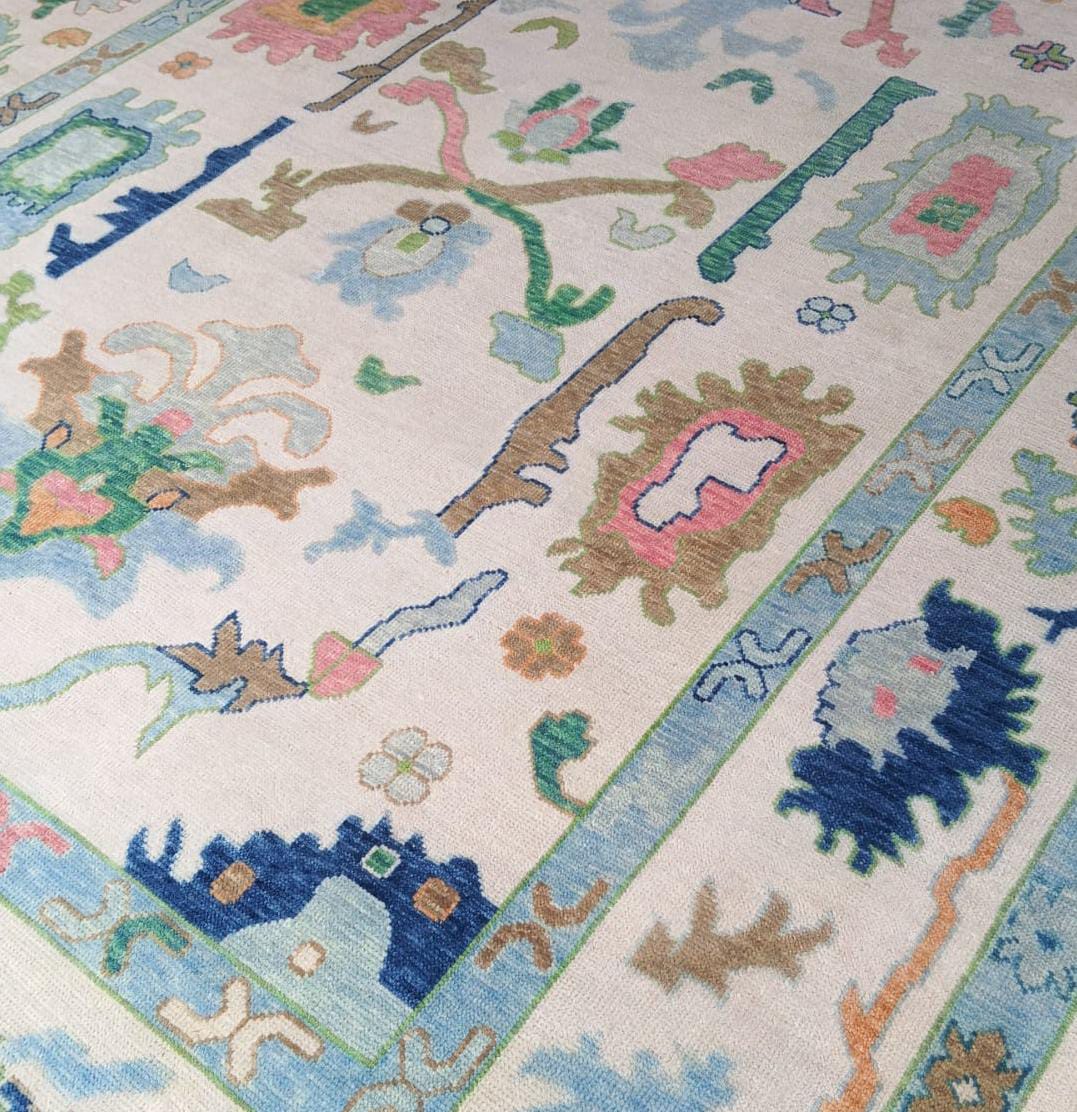 Corner and border detail of handmade Oushak rug in blue ivory and green shades