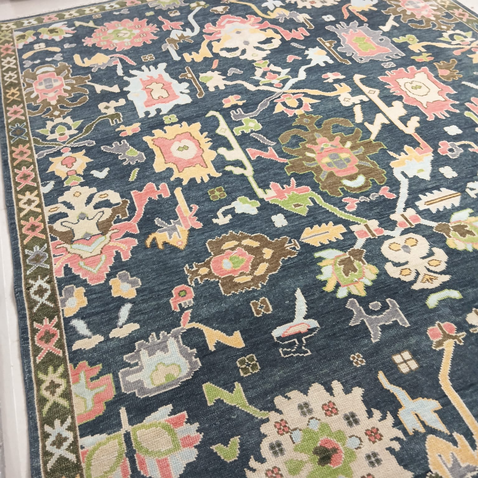 Overall design of handmade Oushak rug with soft pastel accents