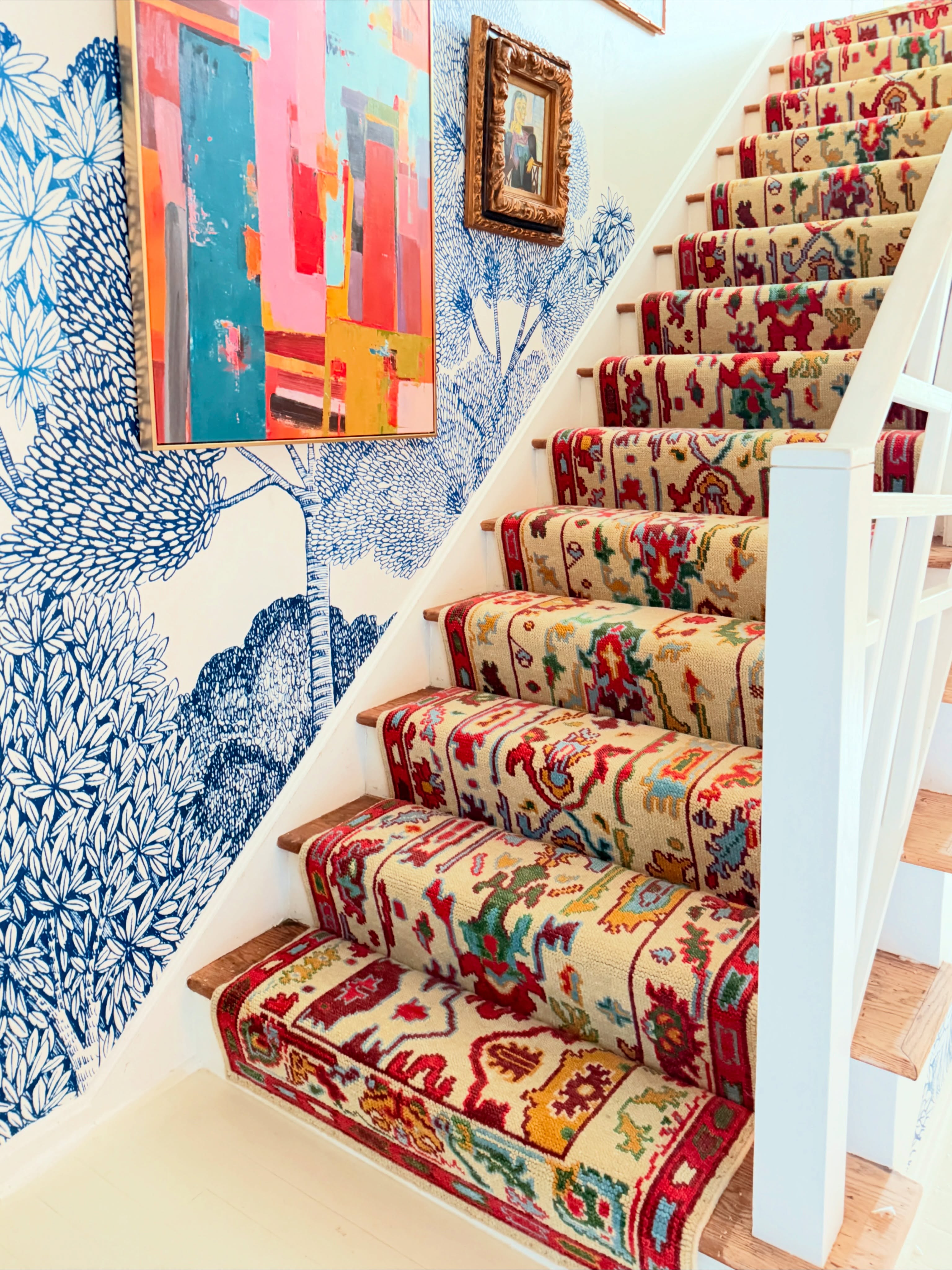 Handmade Oushak stair runner carpet in ivory, red and blue installed on a wooden staircase with traditional vintage pattern