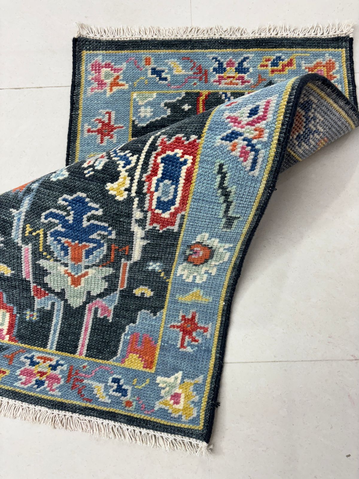 Detailed view of traditional Oushak rug border with multicolor geometric patterns in wool