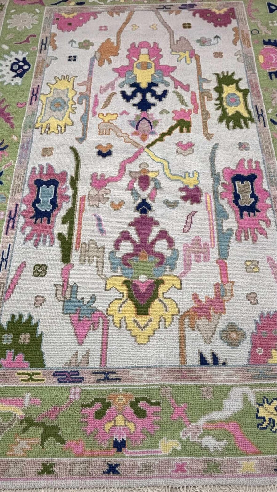 Detailed texture view of handmade pastel wool rug with colorful Turkish inspired patterns
