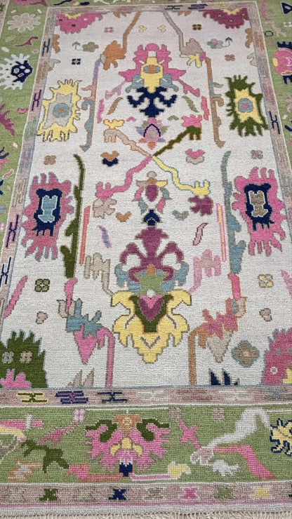 Detailed texture view of handmade pastel wool rug with colorful Turkish inspired patterns