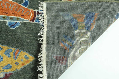 Close-up of a patterned rug with colorful fish design on a gray background