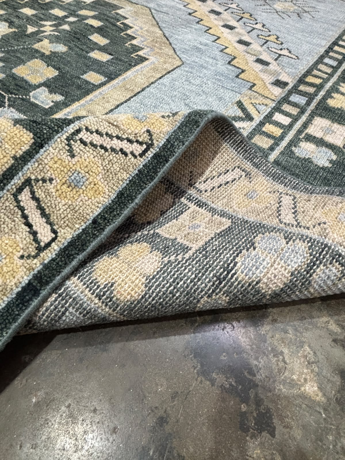 Back side of handmade wool Oushak rug showing tightly woven artisan construction and premium craftsmanship.