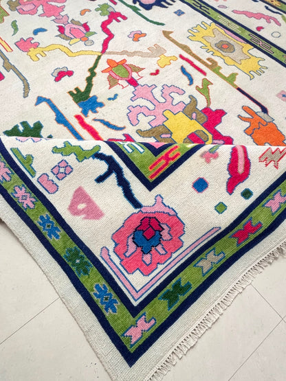 Folded corner of a handmade wool rug showing thick pile, soft texture and handcrafted Scandinavian folk art pattern.