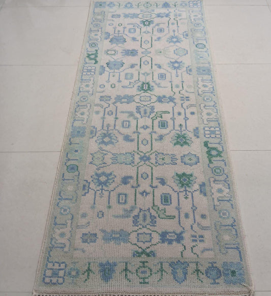 Handwoven blue and green wool runner rug with tribal geometric pattern