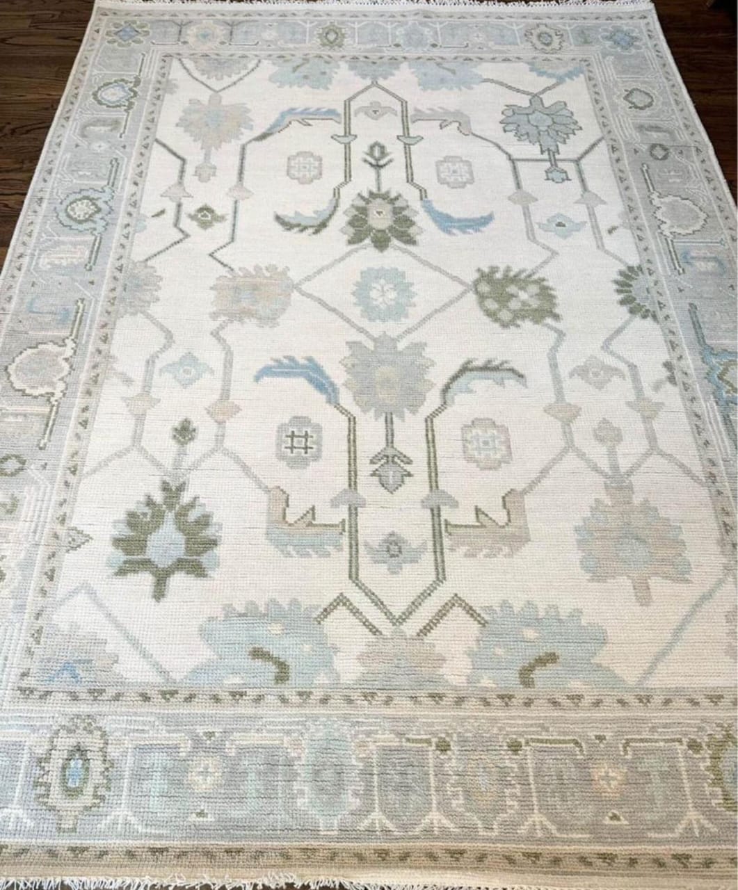 Handwoven ivory and blue Oushak wool area rug with soft traditional floral motifs