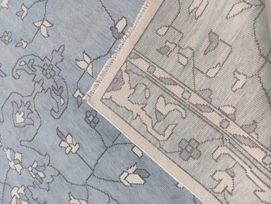 Handwoven light blue wool rug showing soft flatweave texture