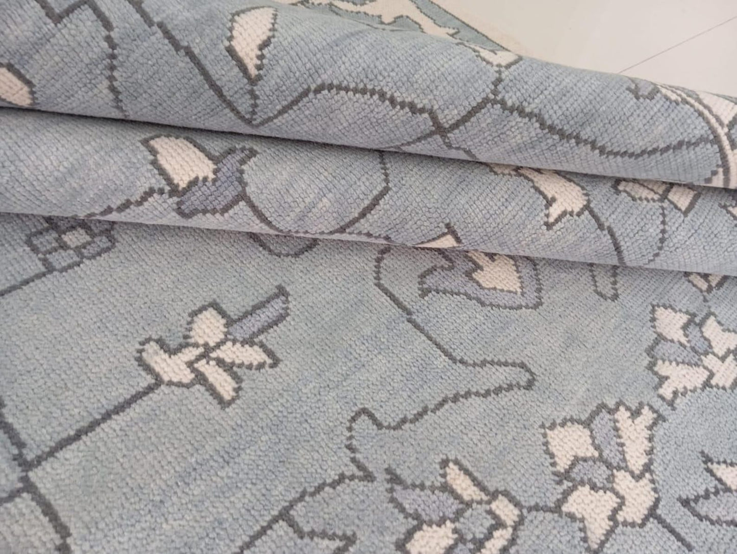 Handwoven light blue wool rug showing soft flatweave texture