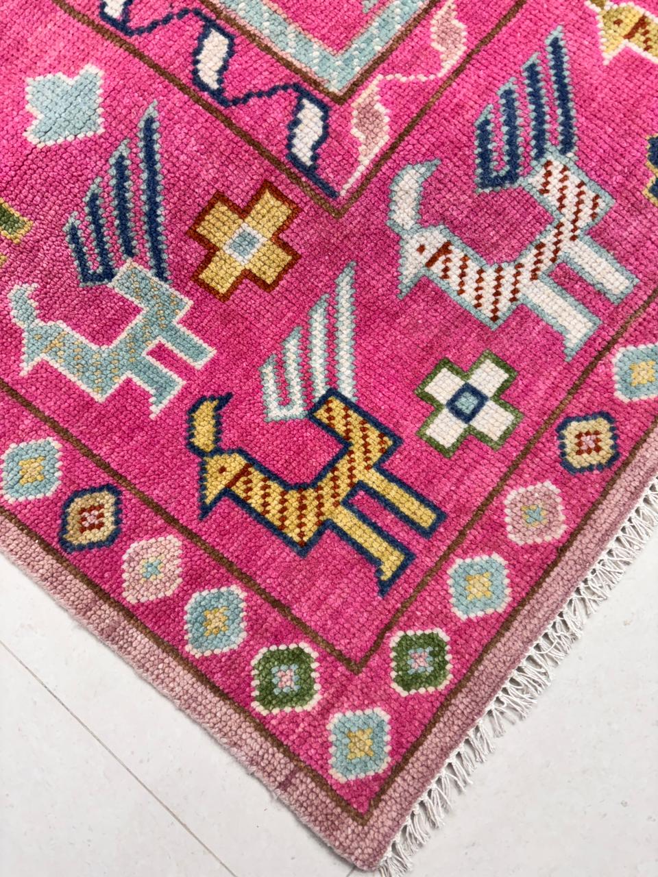 Corner detail of handwoven tribal Oushak rug with geometric border design