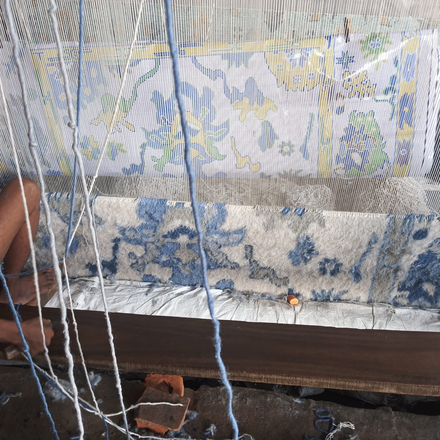 Handwoven Oushak rug being woven on a traditional loom, showing the craftsmanship and weaving process behind each rug