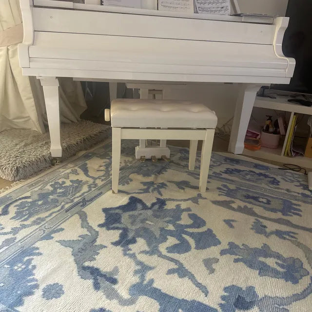 Handwoven Oushak wool rug with blue floral pattern styled in a calm living room interior