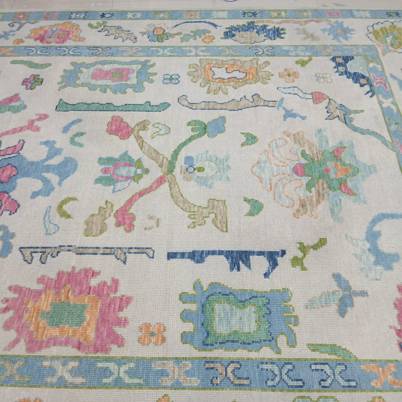 Handwoven Oushak wool rug with pastel blue floral design