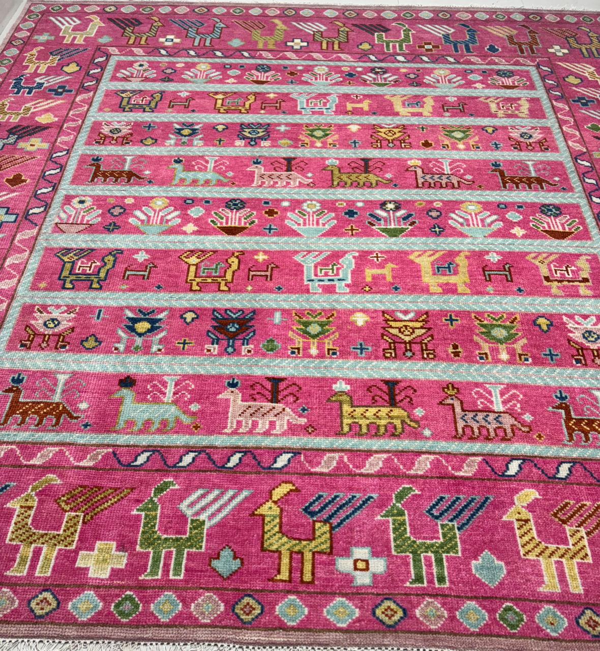 Handwoven tribal Oushak wool rug with pink base and multicolor animal motifs