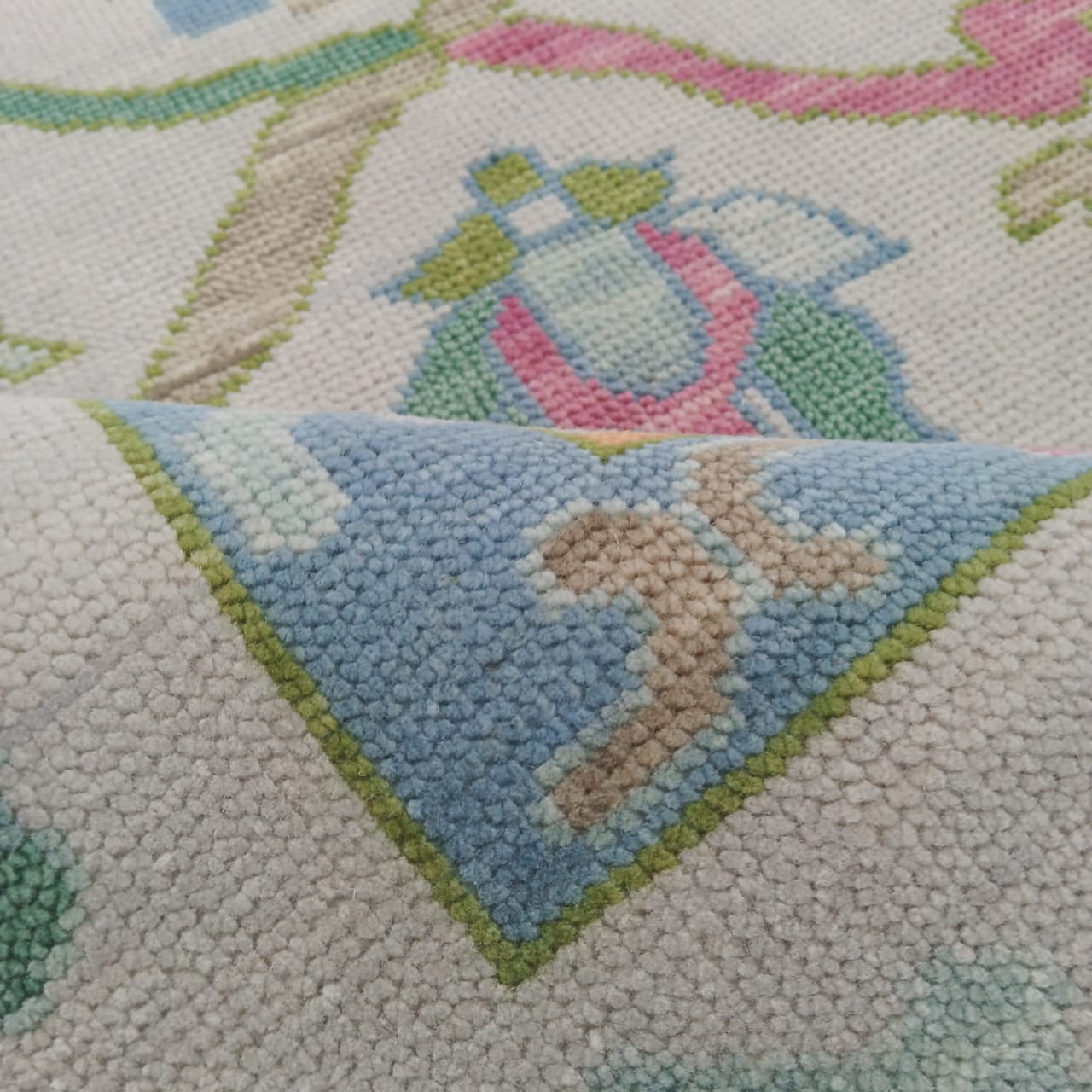 Close-up of a embroidered design with a penguin and child on a textured fabric background.