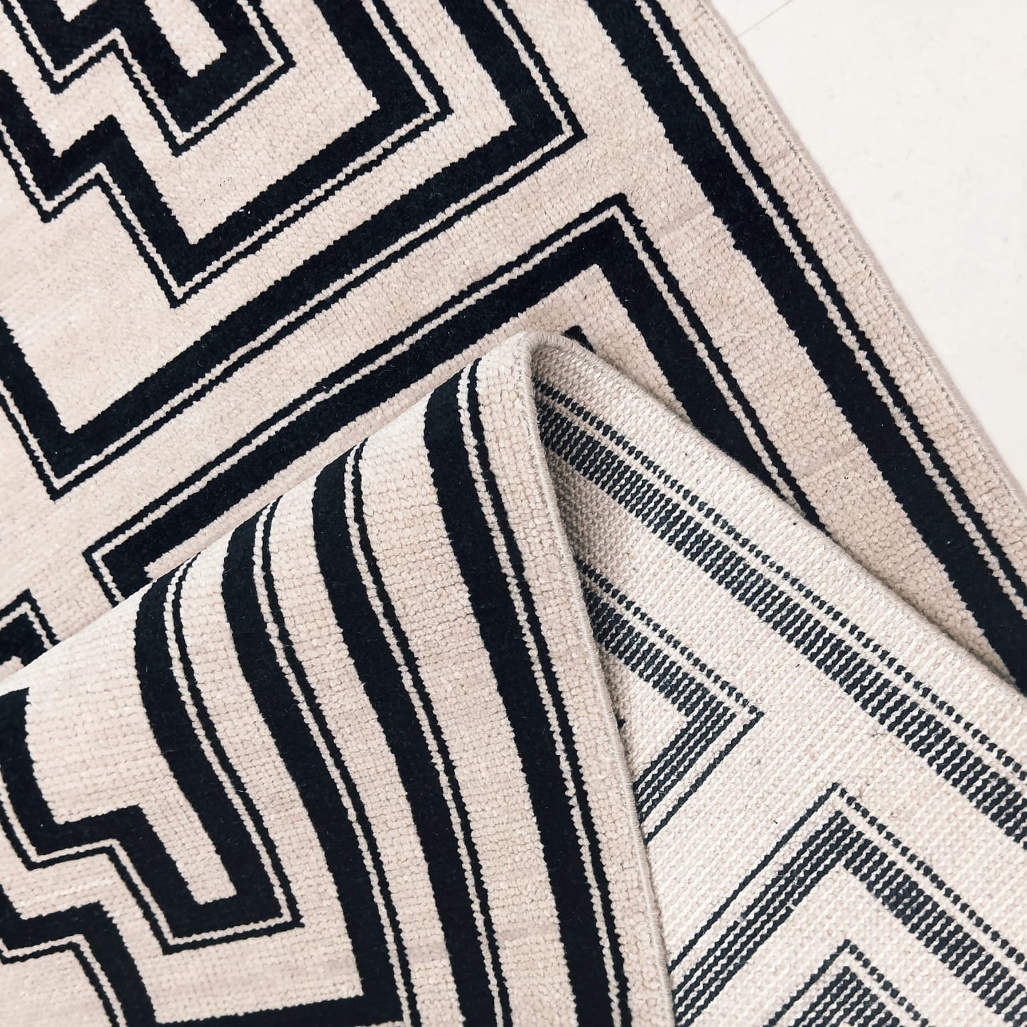 Flatwoven back detail of black and ivory handwoven wool rug
