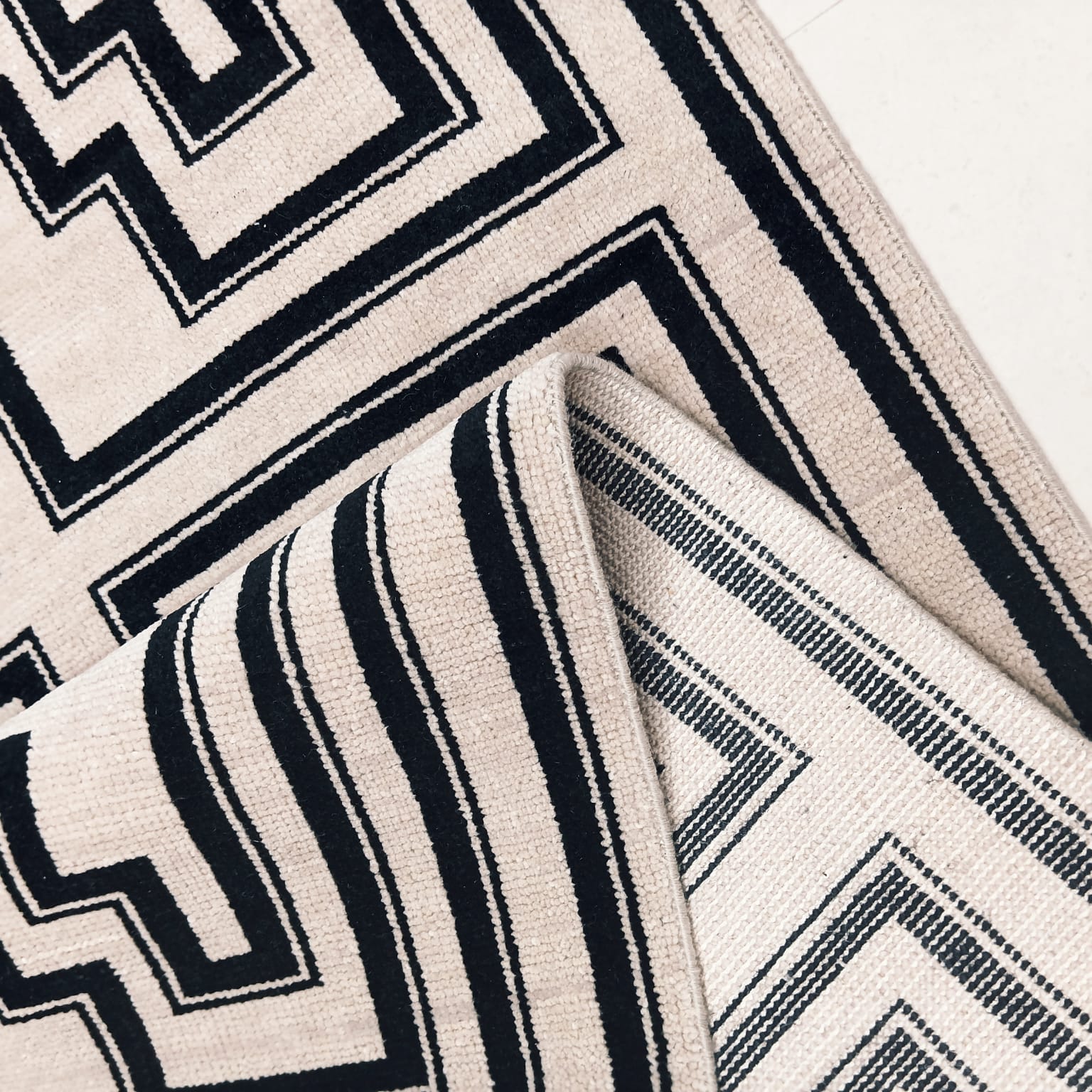 Flatwoven back detail of black and ivory handwoven wool rug
