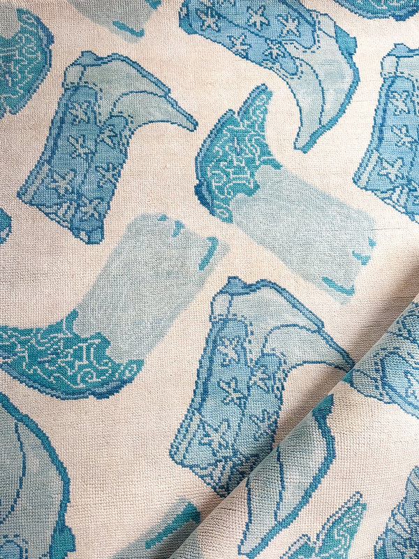 Ivory area rug with repeating blue and teal bird motif pattern