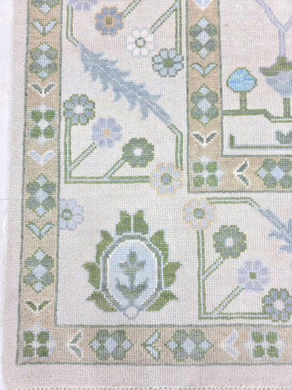Ivory blue floral rug showing traditional botanical motifs and detailed decorative border