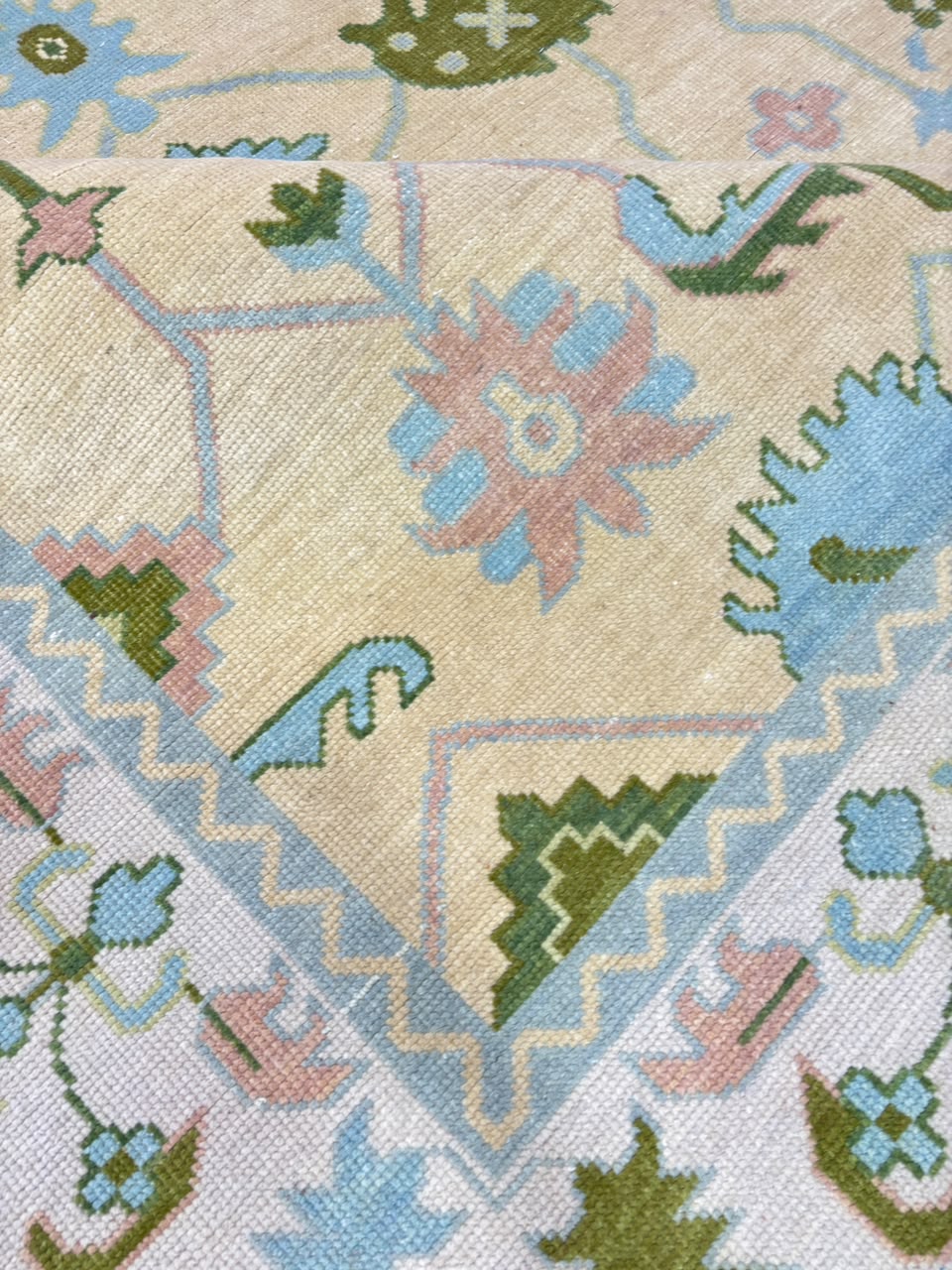 Full view of handmade ivory blue vintage Oushak wool rug with traditional floral pattern.