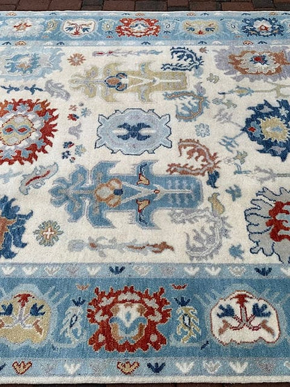 Close view of ivory and blue Oushak rug pattern with floral medallions and decorative elements