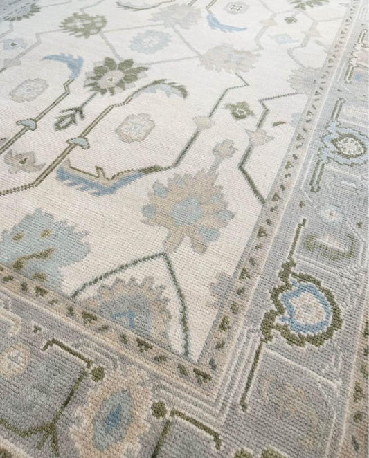 Close-up of handwoven Oushak wool rug showing ivory and blue border details