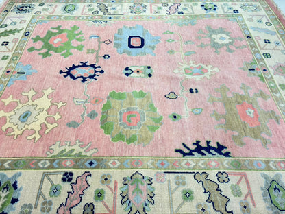 Decorative ivory border with floral motifs on handmade blush pink Oushak rug