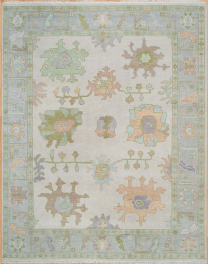 Full view of ivory and mint green floral Oushak-style rug with pastel botanical motifs and decorative border.