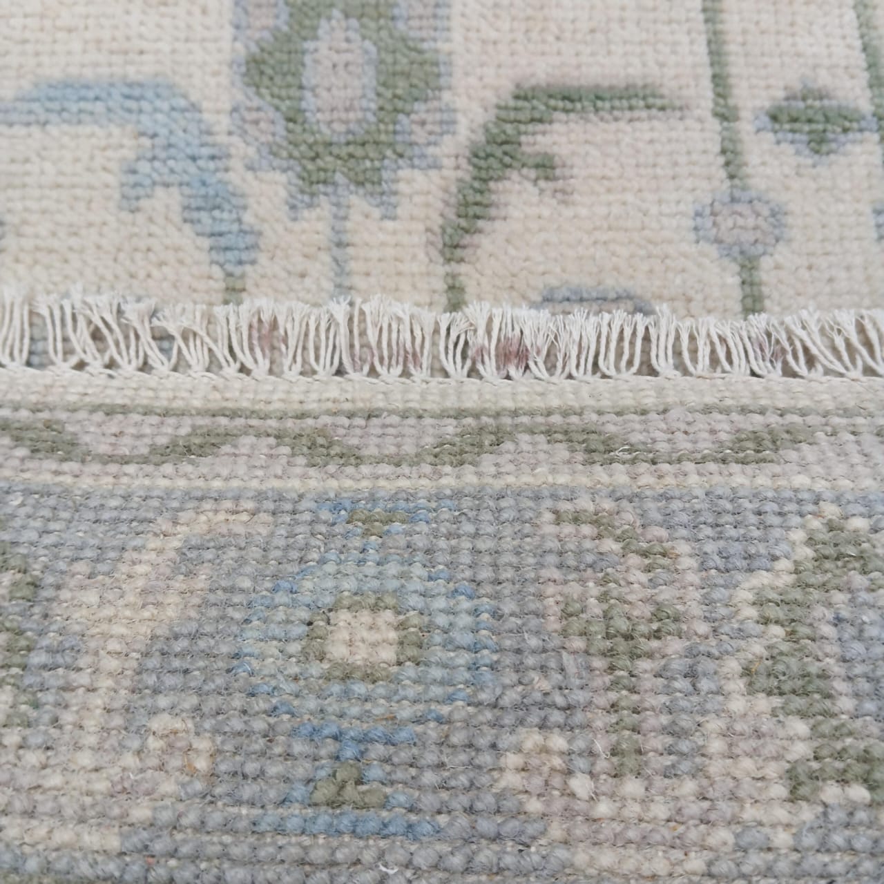 Ivory Oushak rug with hand-knotted fringe detail and wool backing