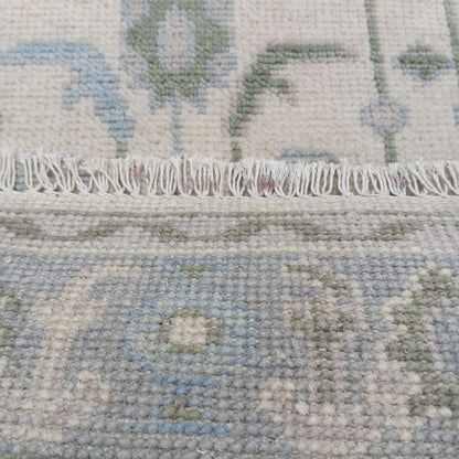 Ivory Oushak rug with hand-knotted fringe detail and wool backing