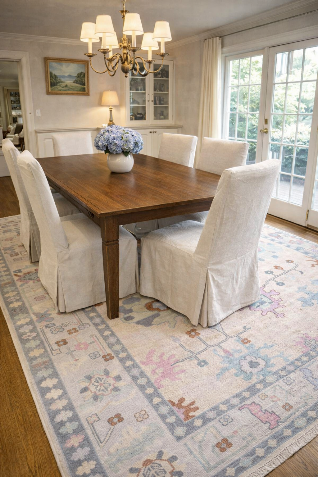 Ivory Oushak handwoven wool rug in dining room setting with wooden table and neutral chairs – real customer image