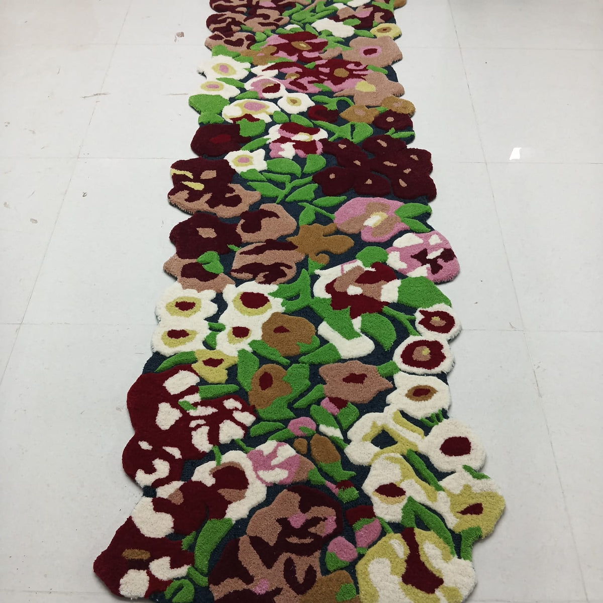 Long view of multicolor floral rug with botanical flowers and green leaves
