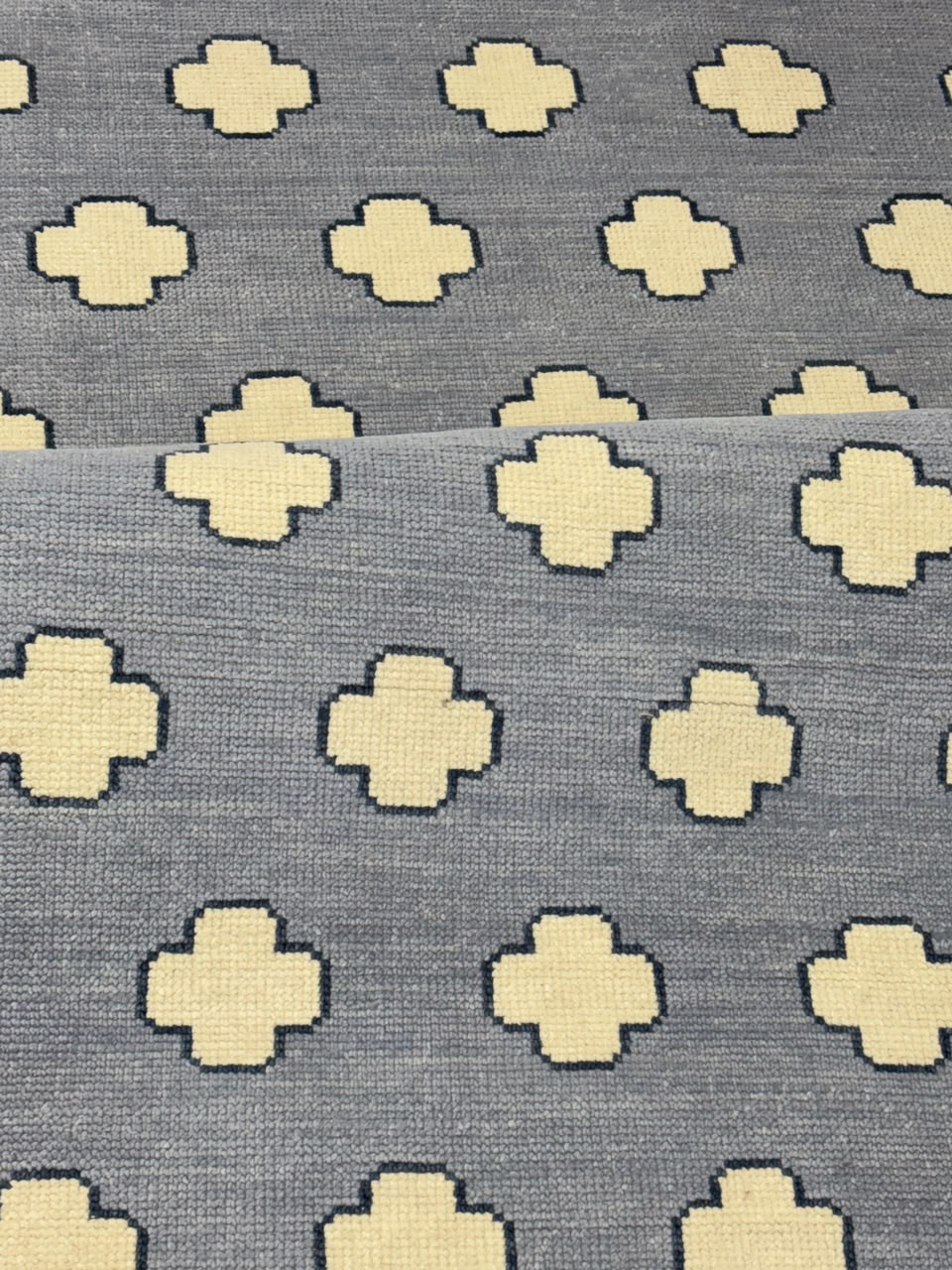 Close-up of premium wool texture on a handmade blue geometric rug.