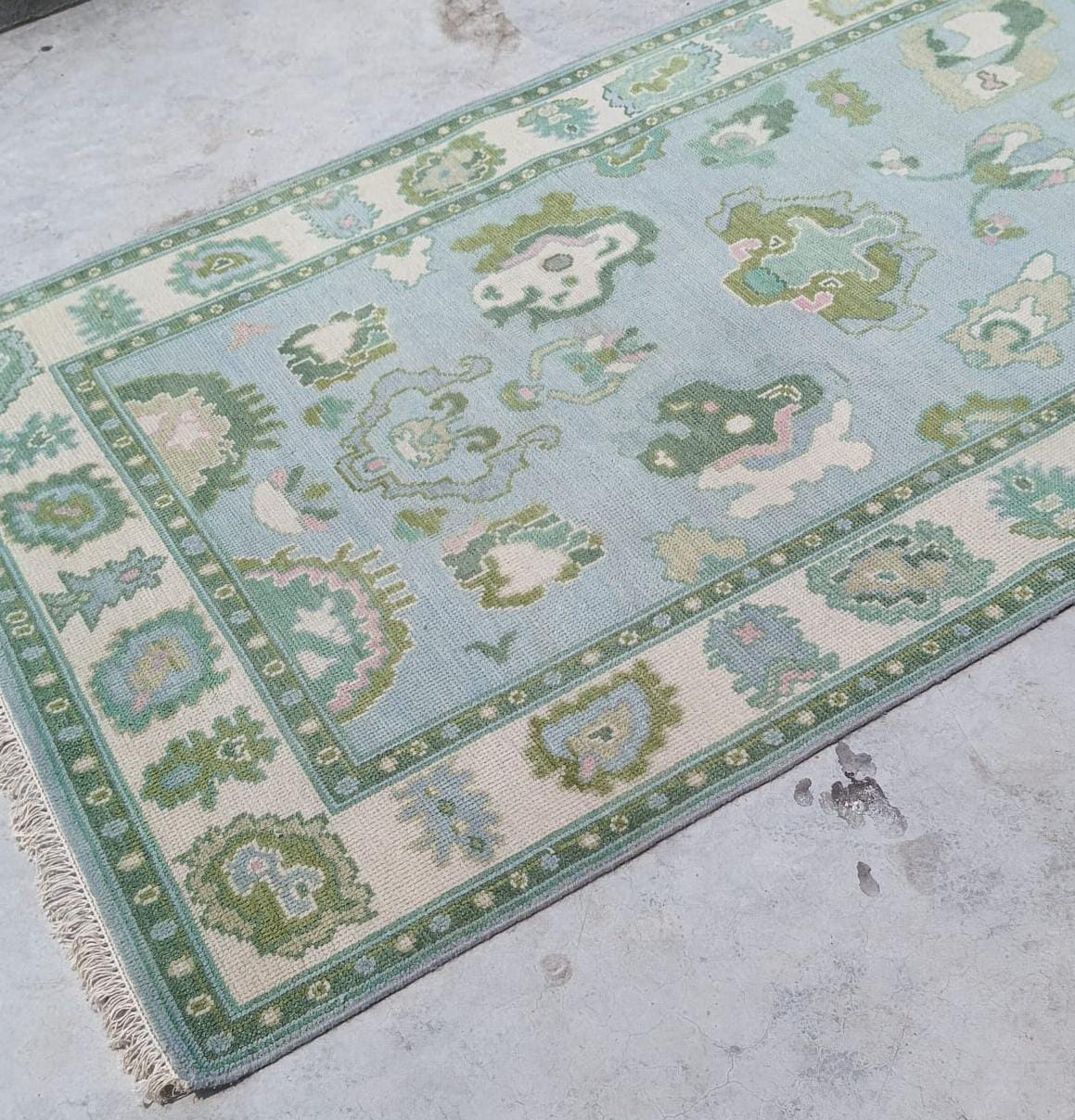 Handwoven wool Oushak rug corner with fringe and detailed floral border