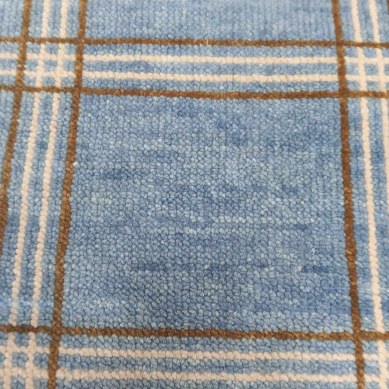 Surface detail of modern blue plaid wool rug with checkered lines