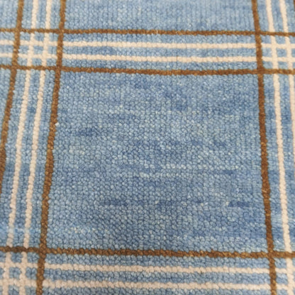 Surface detail of modern blue plaid wool rug with checkered lines
