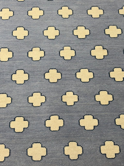 Detailed view of repeating quatrefoil motifs woven into a handmade wool area rug.