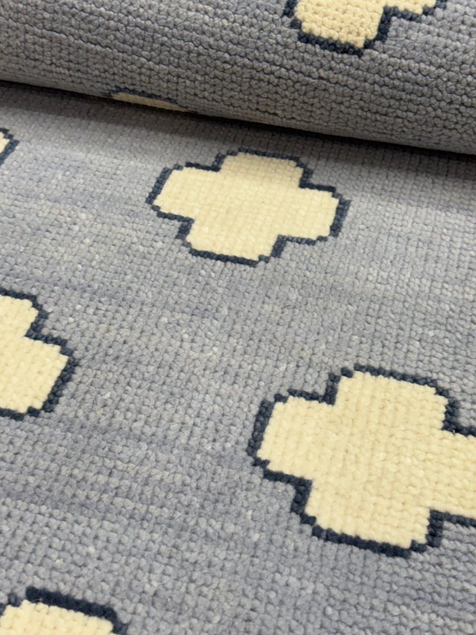 Close-up of premium wool texture on a handmade blue geometric rug.