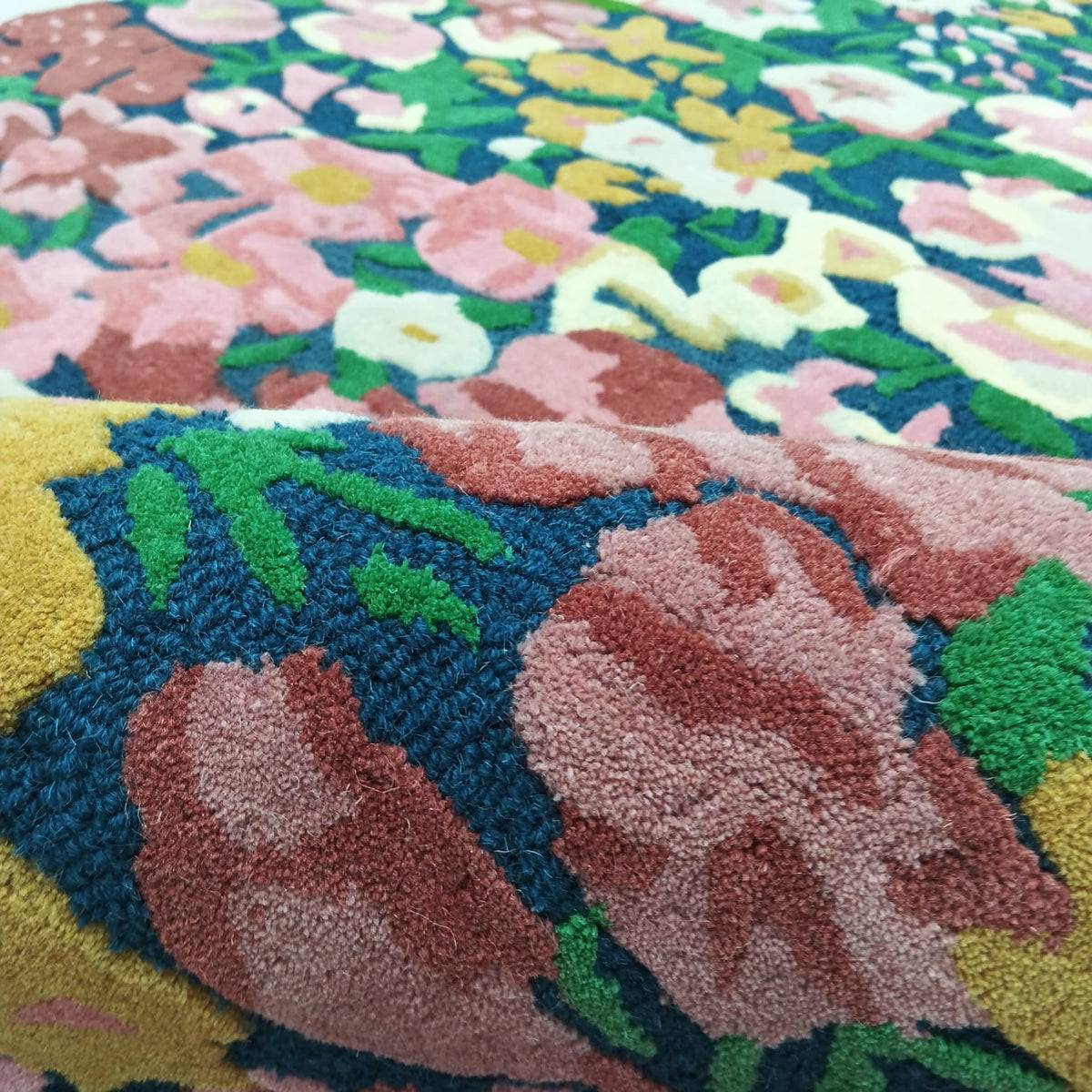 Raised floral pile texture on a multicolor pink and burgundy area rug