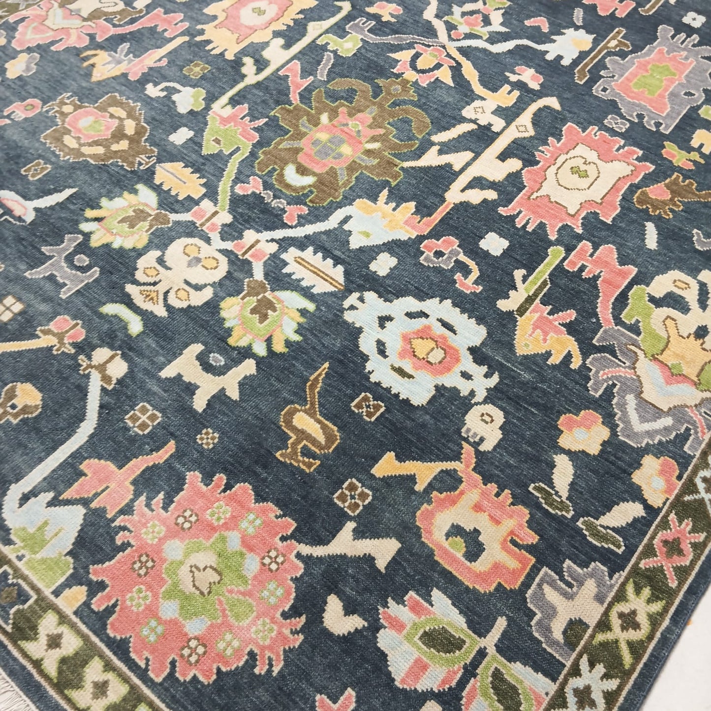 Angled view of handmade navy blue Oushak area rug