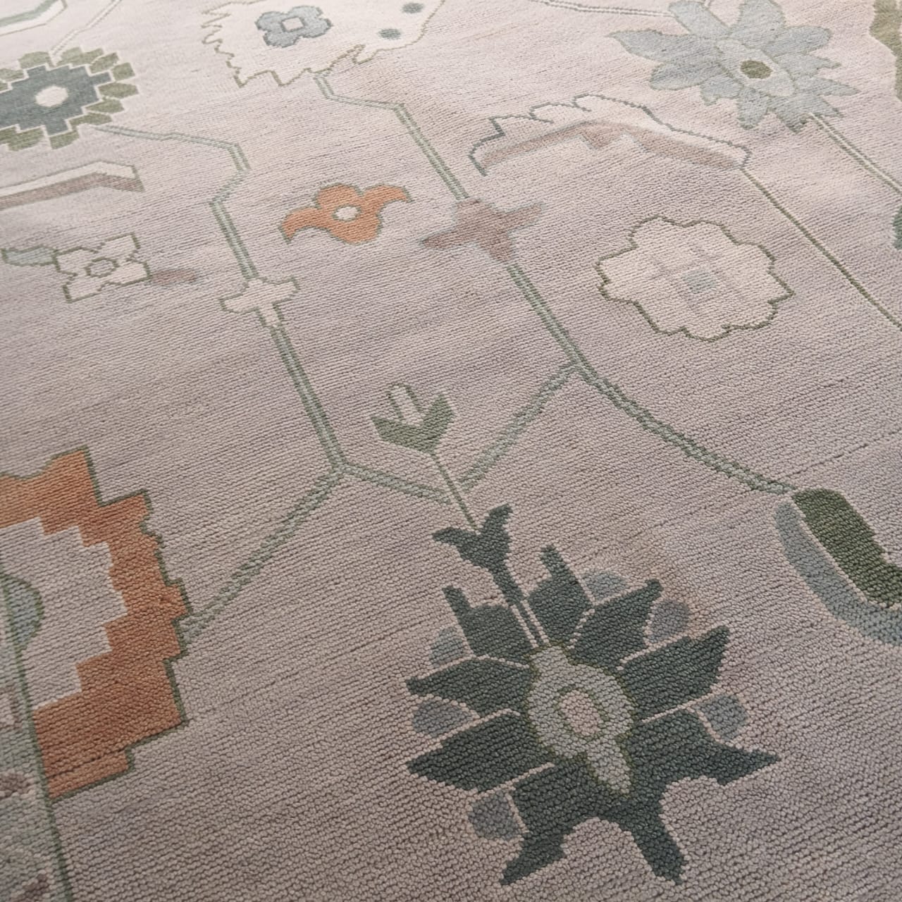 Close-up of a patterned rug with geometric shapes and floral elements.