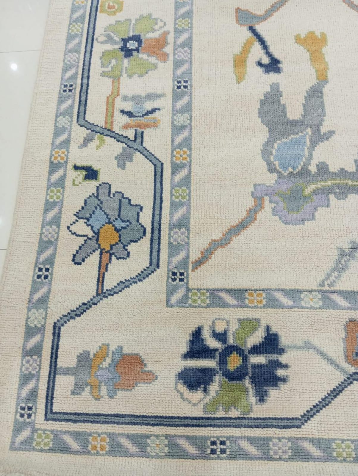 Close-up of handwoven Oushak rug border with floral pattern and soft wool texture