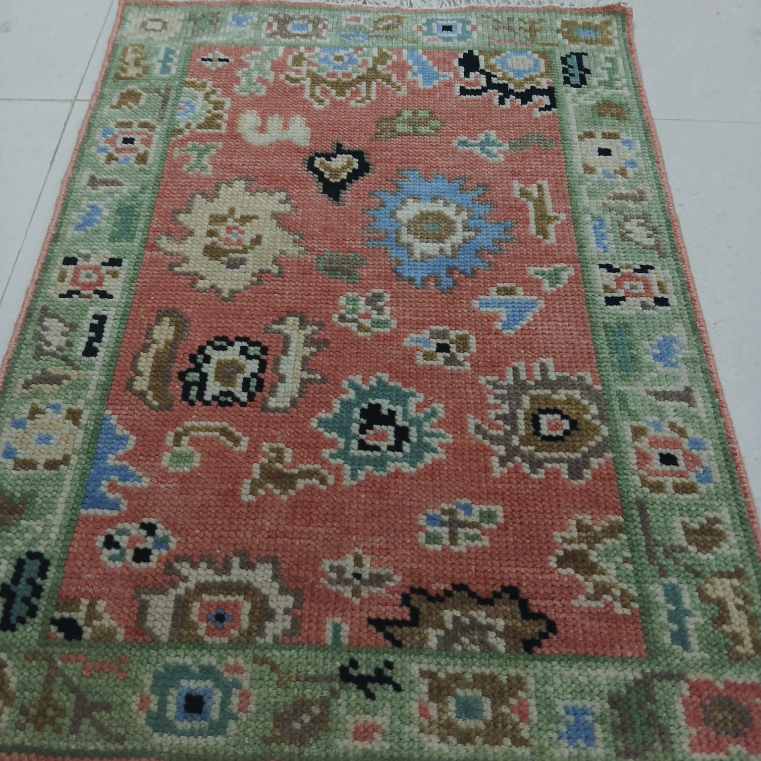 Handwoven Oushak rug border detail with green and cream traditional Turkish patterns