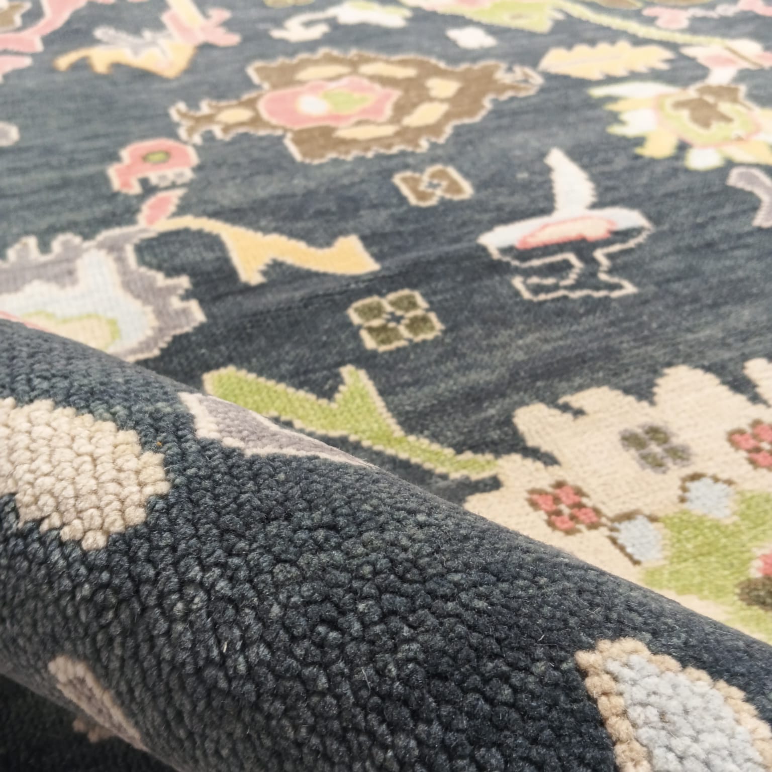 Close-up of tribal and floral motifs on handmade Oushak rug