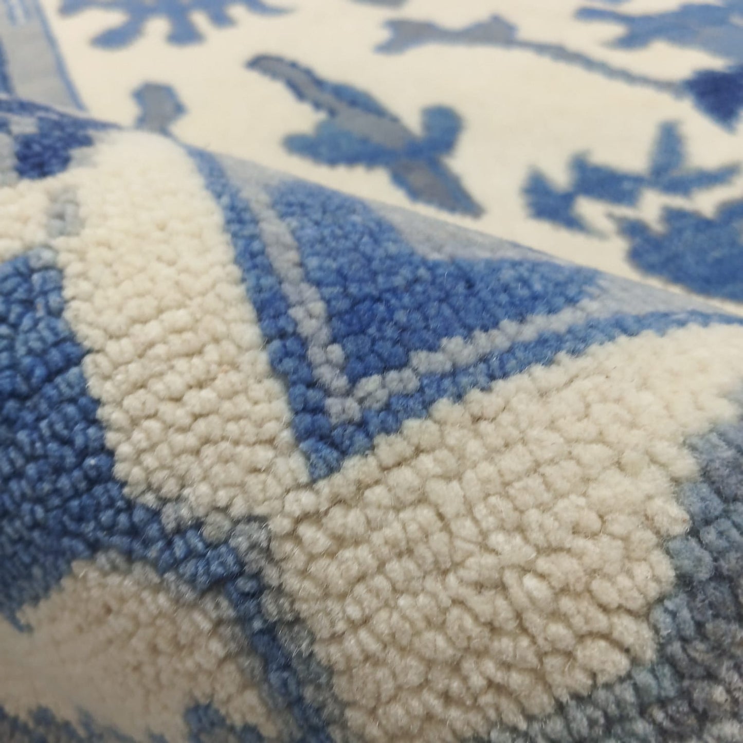 Close-up of natural wool pile texture on handmade rug
