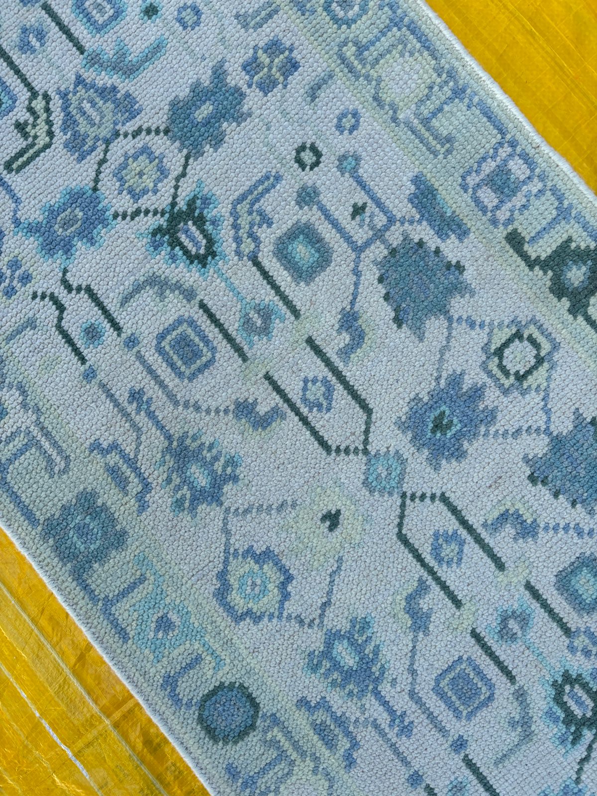 Close-up of blue geometric pattern on hand-knotted Oushak wool rug