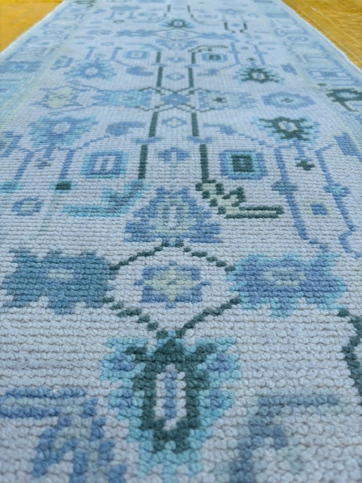 Hand-finished edge detail of blue Oushak runner rug in wool