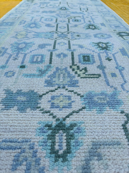 Hand-finished edge detail of blue Oushak runner rug in wool